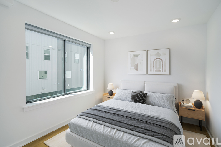 A bedroom with a large bed and a window overlooking a building.