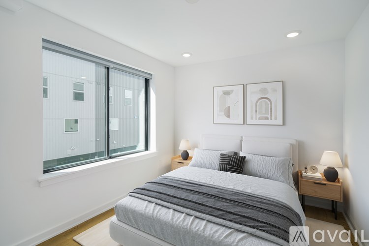 A bedroom with a large bed and a window overlooking a building.
