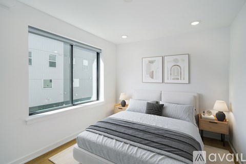 A bedroom with a large bed and a window overlooking a building.
