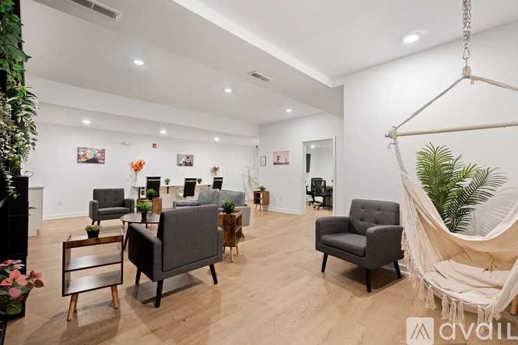 A room with a hanging chair and several chairs and tables.