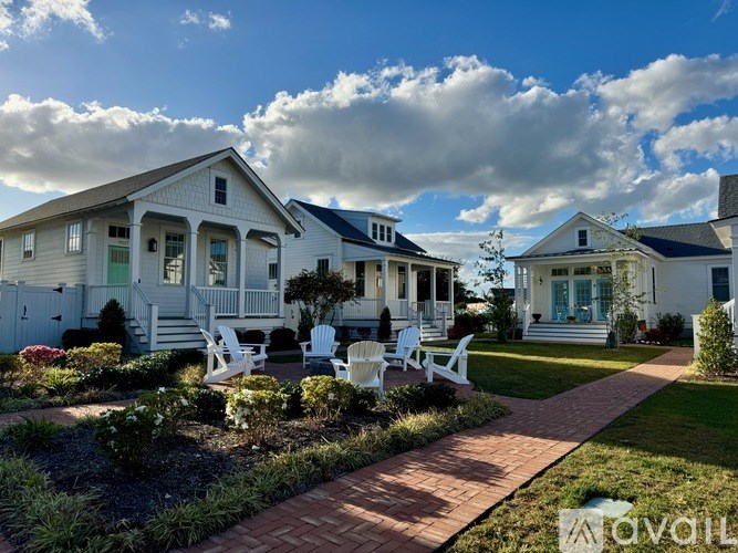 A row of houses with white lawn chairs in front of them.