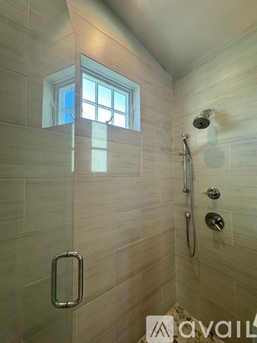 A bathroom with a window in the shower.