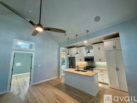 A modern kitchen with a fan and a view of the outside through a window.