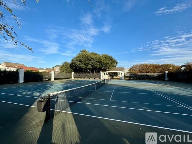 A tennis court with a net and a sign that says "AVAIL".