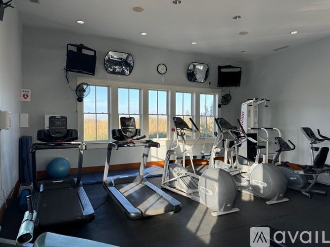 A gym with treadmills, exercise bikes, and other equipment.