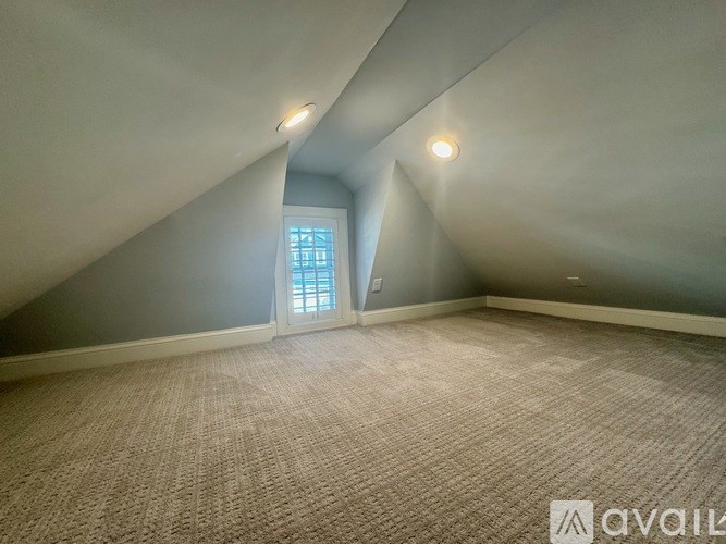 A room with a carpeted floor and a window.