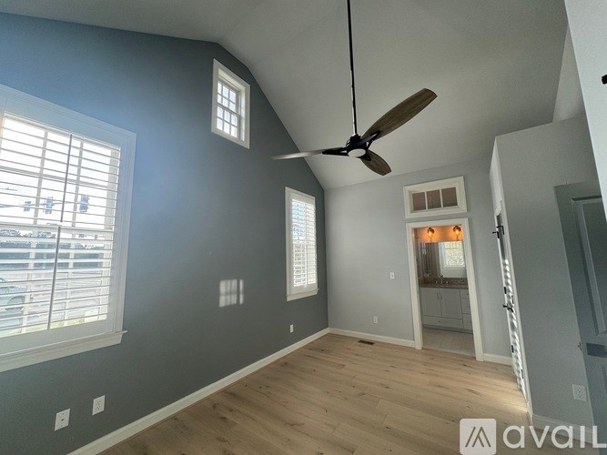 A room with a ceiling fan and a window with blinds.