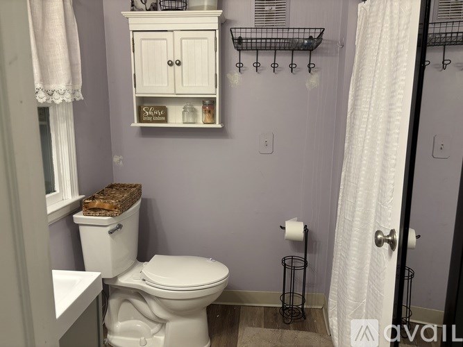 A white toilet in a bathroom with a cabinet above it.