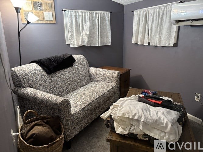 A living room with a grey couch, a wooden coffee table, and a basket on the floor.