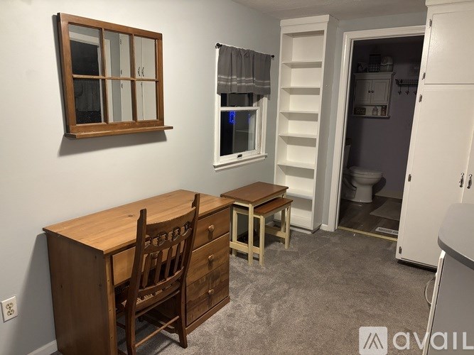 A room with a desk, chair, and a window.