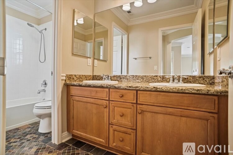 A bathroom with a wooden vanity and a walk-in shower.