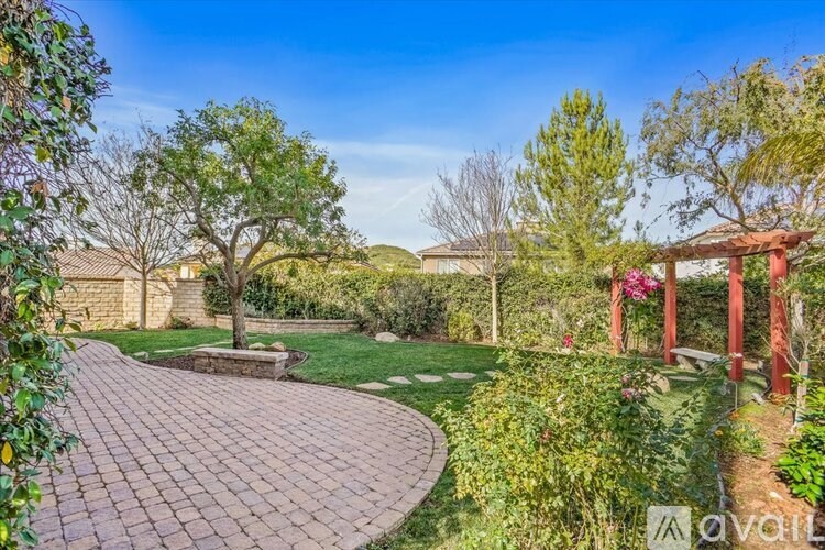 A garden with a red torii gate and a curved brick pathway.