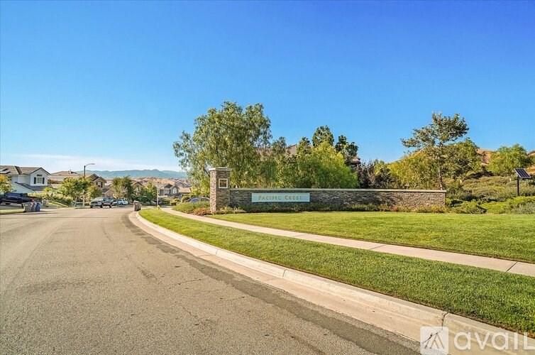 A street view of a residential area with houses and trees.