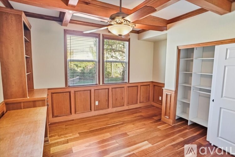 A room with wooden floors and a ceiling fan.