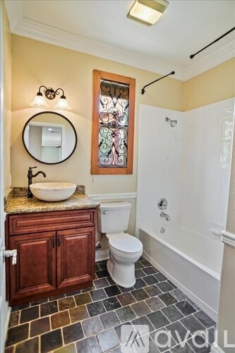 A bathroom with a toilet, sink, and a mirror.