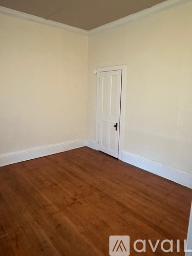 A room with a wooden floor and a white door.