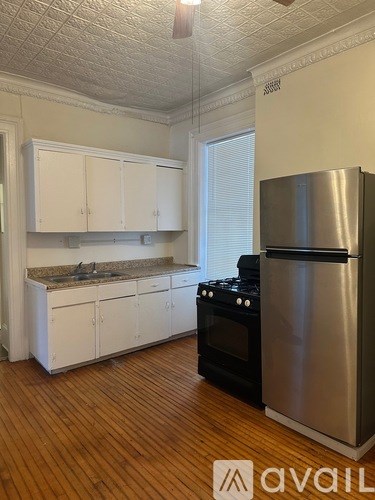 A kitchen with white cabinets and a stainless steel refrigerator.