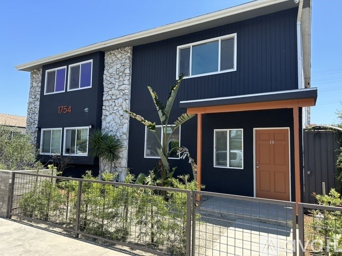 A modern house with a blue exterior and a brown door.