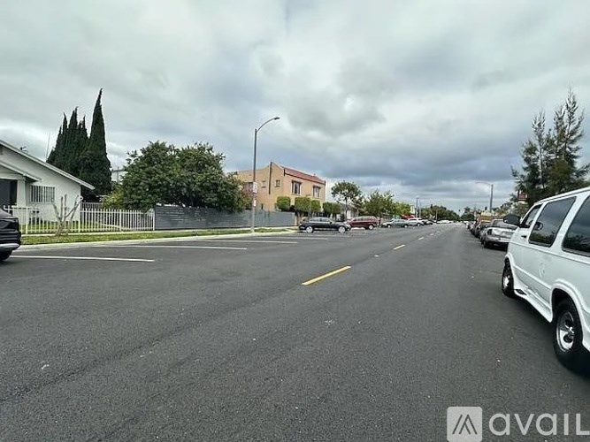 A parking lot with cars and a white car on the right side.