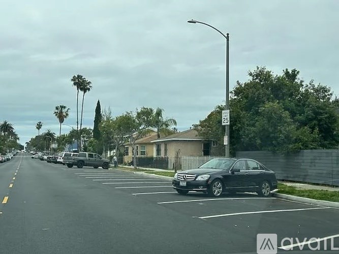 A black car is parked on the side of a street.