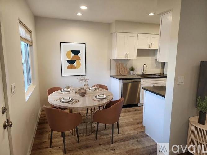 A dining room with a round table set for six with chairs around it.