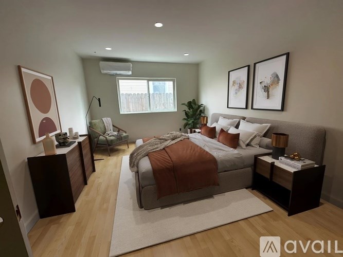 A bedroom with a large bed and a window with blinds.