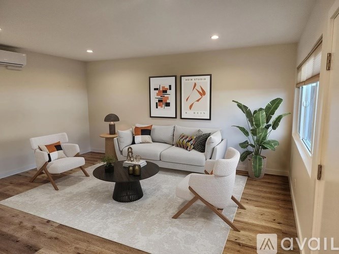 A living room with a white sofa, two chairs, and a coffee table.