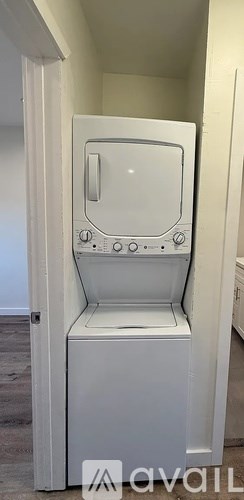 A white washing machine is sitting in a small space.