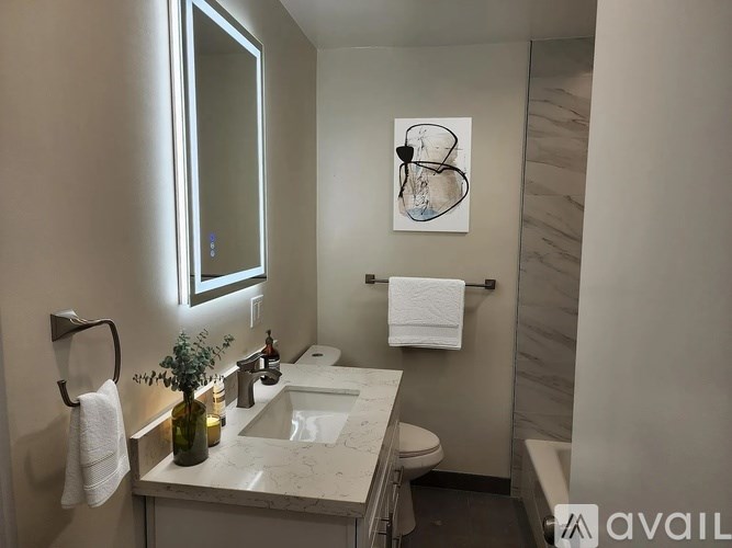A bathroom with a marble countertop and a large mirror.