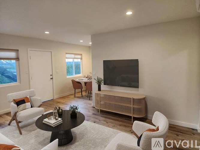 A living room with a television, a chair, and a table.
