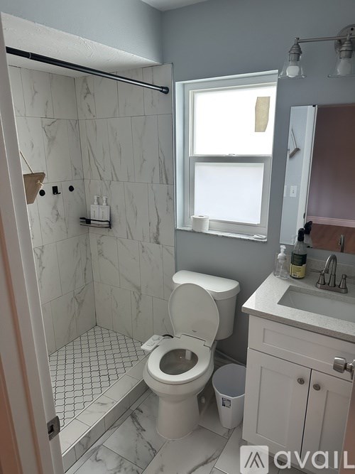 A white toilet in a bathroom with marble tiles.