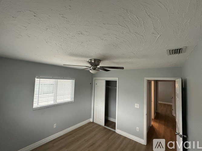 A room with a ceiling fan and two doors.