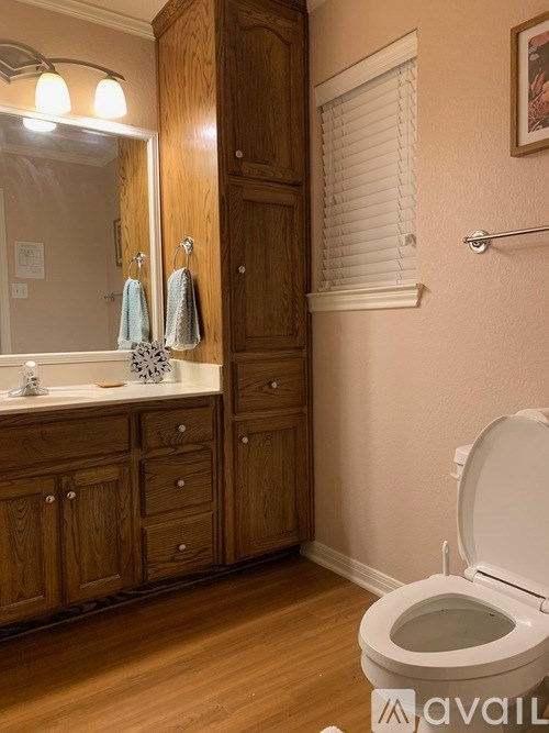 A bathroom with wooden cabinets and a white toilet.