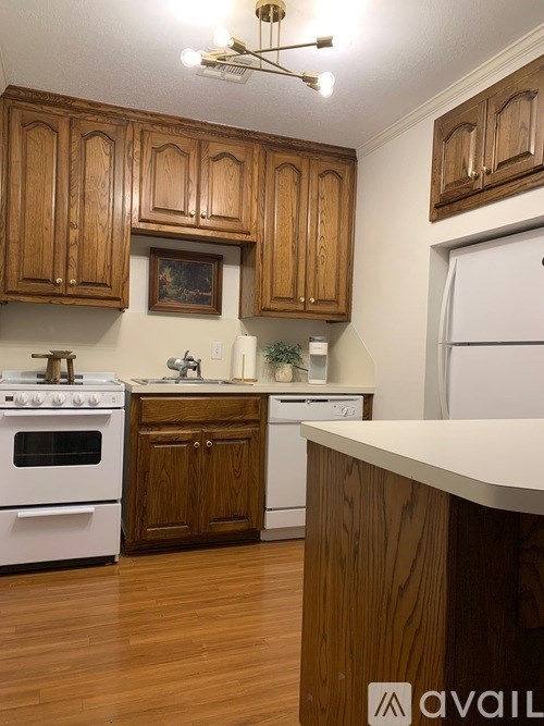 A kitchen with wooden cabinets and white appliances.