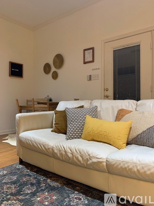 A living room with a white couch and a rug.