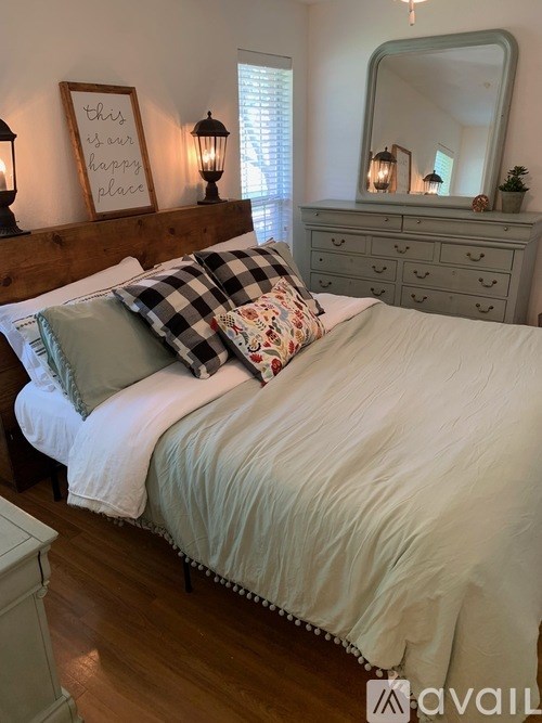 A bedroom with a bed, dresser, and mirror.