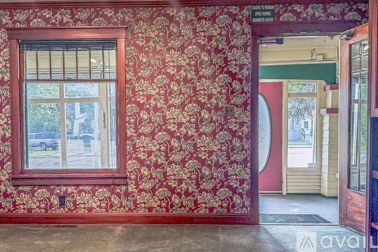 A room with a red wallpaper and a window.