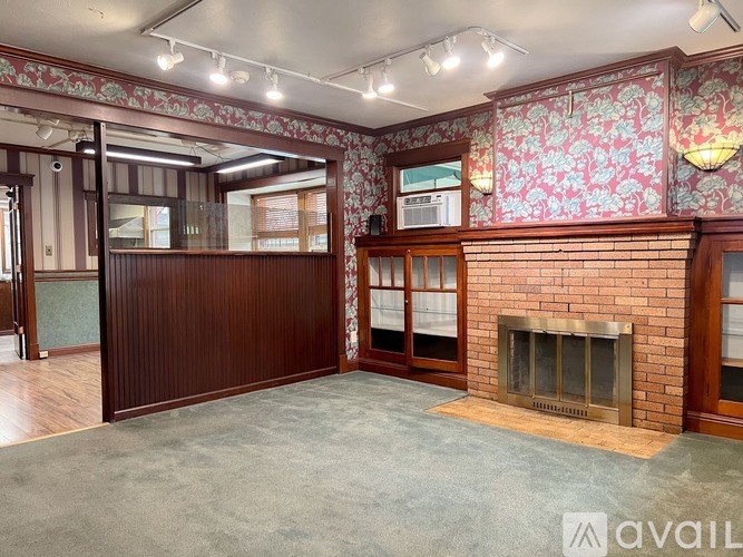 A room with a fireplace and a wallpapered wall.