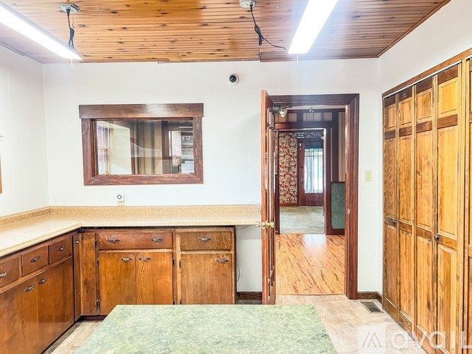 A room with wooden furniture and a green rug.