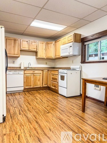 A kitchen with wooden cabinets and white appliances.