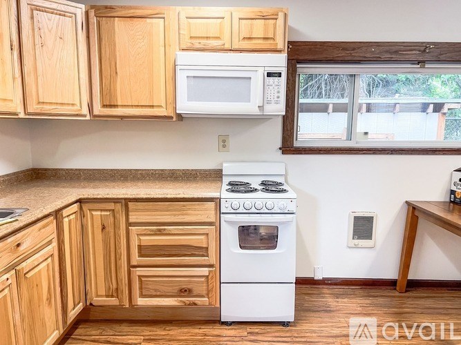 A kitchen with wooden cabinets and a white stove.