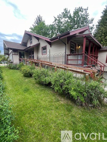 A house with a red roof and a porch.