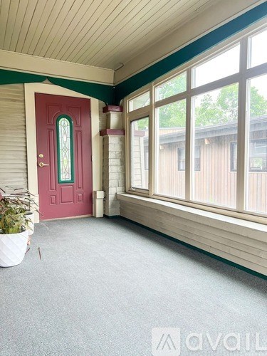 A red door with a glass window is on the left side of the room.