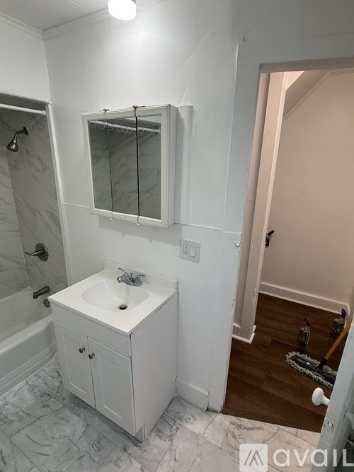 A bathroom with a white cabinet and sink.