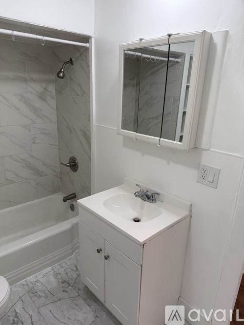 A white bathroom with a marble floor and a white sink.