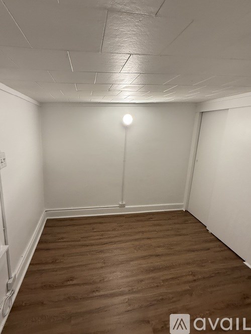 A room with wooden flooring and white walls.