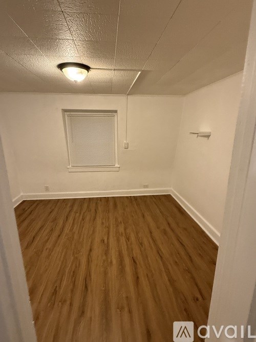 A room with wooden flooring and a window.