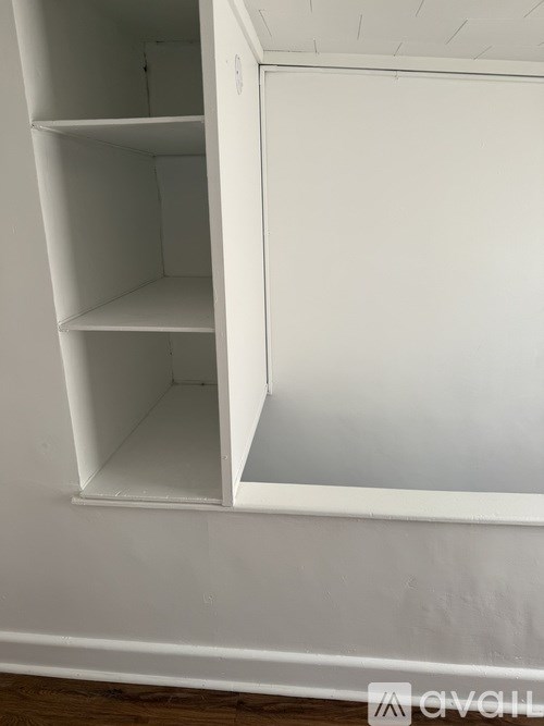 A white shelving unit with three shelves is open.