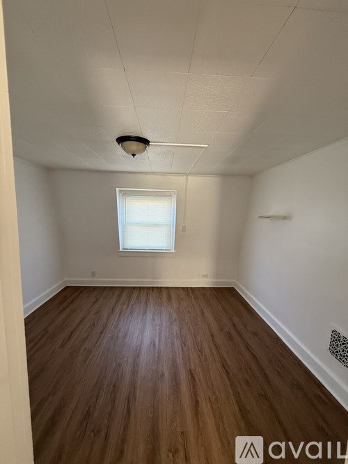 A room with wooden floors and a window.