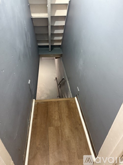 A stairway with wooden steps and a metal railing.